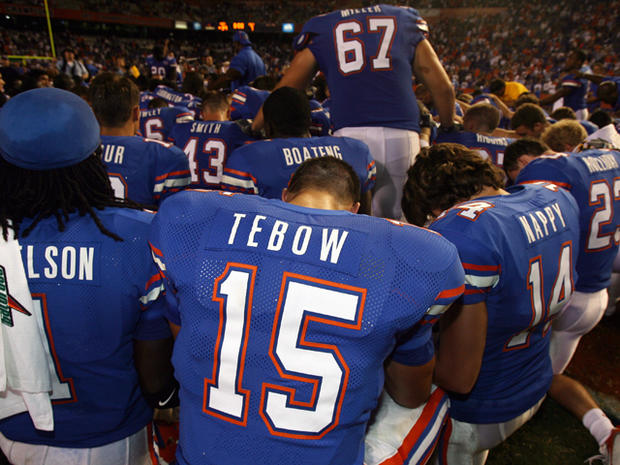 Tim Tebow prays with teammates 