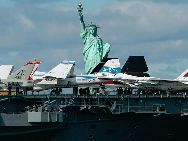 The aircraft carrier USS Intrepid passes by the Statue of Liberty en route to her dock at Pier 86 on the west side of Manhattan Oct. 2, 2008, in New York City. The Intrepid Sea, Air & Space Museum returned to Manhattan after a nearly two-year, $120 millio 