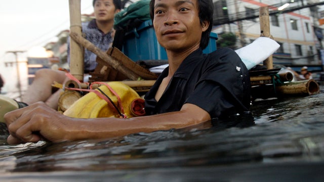 A Thai man wades along chest-deep floodwaters in the outskirts of Bangkok Oct. 27, 2011. Residents poured out of the Thai capital by bus, plane and train, heeding government warnings to use a special five-day holiday to evacuate parts of the flood-threate 