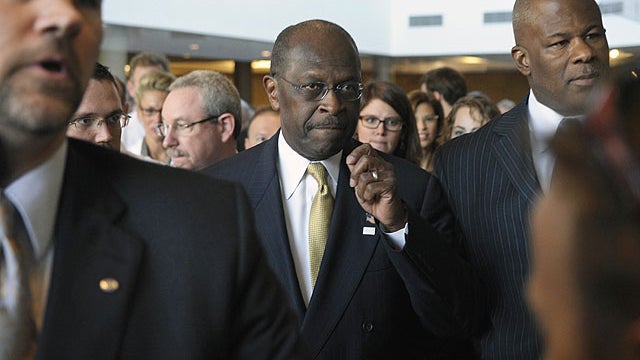 Republican presidential candidate Herman Cain, center, is surrounded by security and staff as he walks through a hotel lobby in Alexandria, Va., Nov. 2, 2011, before speaking after meeting with doctors attending the Docs4PatientCare conference.  
