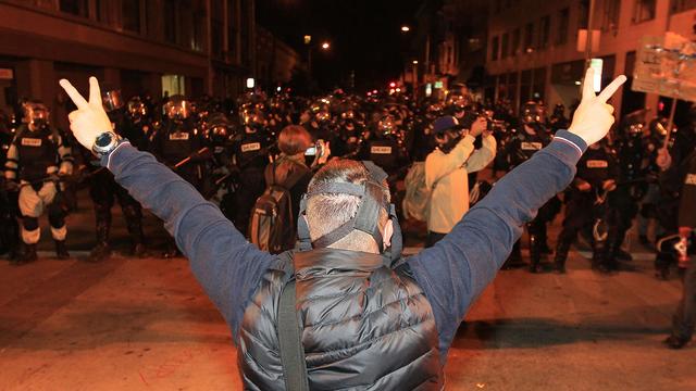 An Occupy protester shows peace signs to Oakland Police officers 