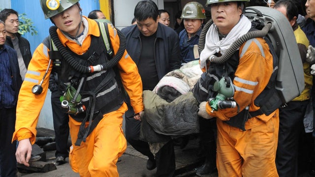 Photo from China's Xinhua news agency shows rescued miner being carried out of coal mine after being trapped underground for more than 30 hours at the Qianqiu Coal Mine in Sanmenxia City, in Henan province Saturday 