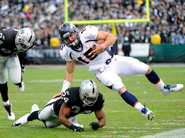 Tim Tebow is knocked out of bounds 