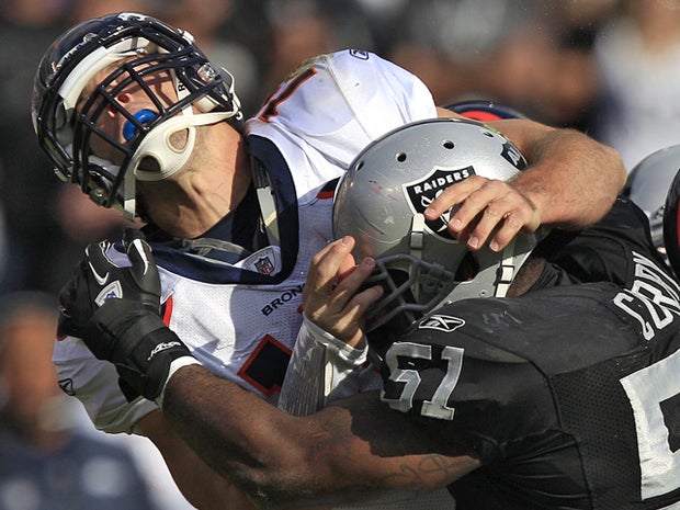 Tim Tebow  is hit by linebacker Aaron Curry 