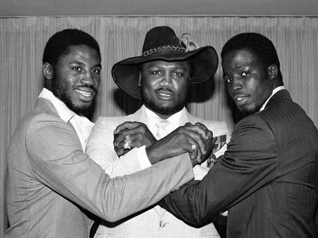 Joe Frazier joins hands with his son Marvis Frazier, left, and James Shuler 