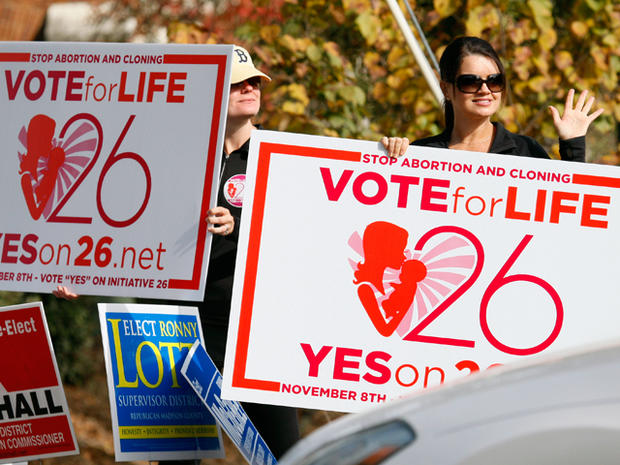 Christi Chandler, left, and Stacy Hawsey, both of Madison and supporters of the Personhood Amendment promote their initiative as they waver signs at drivers in the midst of last minute campaigning Tuesday, Nov. 8, 2011 in Madison, Miss. The Mississippi measure that would define life as beginning at conception was given a decent chance of approval. Passage would be the first victory in the country for the so-called personhood movement, which aims to make abortion all but illegal. Similar attempts have failed in Colorado and are under way elsewhere. 