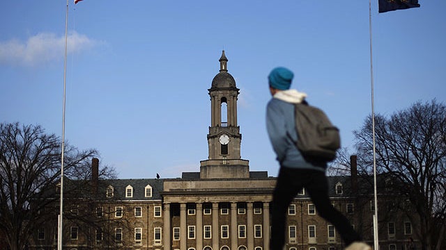 A students walks in front of the Old Main building on the Penn State campus Friday, Nov. 11, 2011, in State College, Pa.  