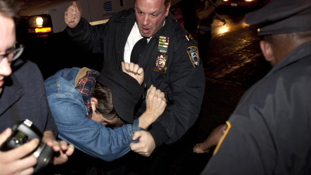 An Occupy Wall Street protester draws contact from a police officer near Zuccotti Park after being ordered to leave the longtime encampment in New York Nov. 15, 2011. 