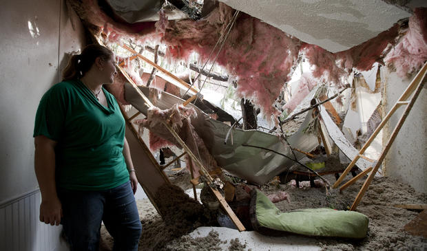 Staci DeGeer stand in the remains of her home in Auburn, Ala. 