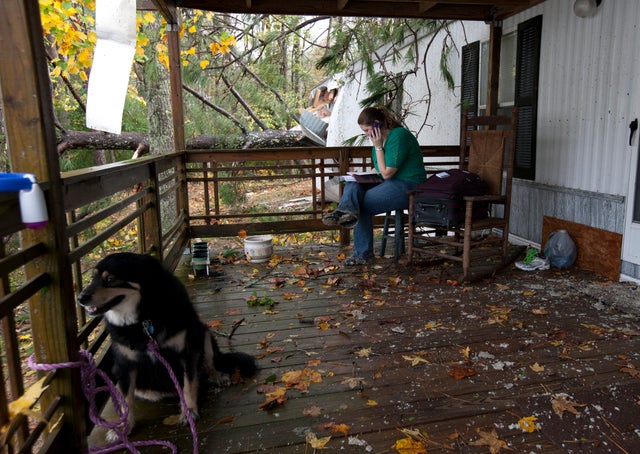 Staci DeGeer sits on her porch and talks with her insurance company  