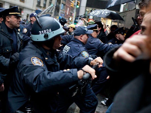 Police use batons to push people affiliated with the Occupy Wall Street Movement back onto the sidewalk during a protest in New York's financial district Nov. 17, 2011. 