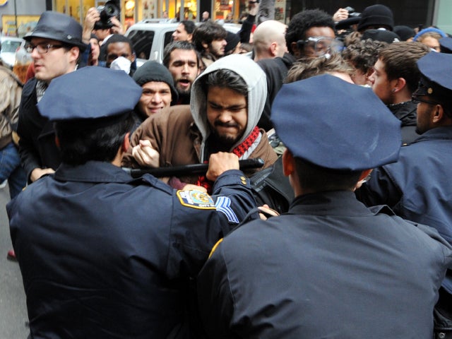 New York Police Department officers push people back as Occupy Wall Street demonstrators converge on Wall Street to mark two months since the movement's birth Nov. 17, 2011. 