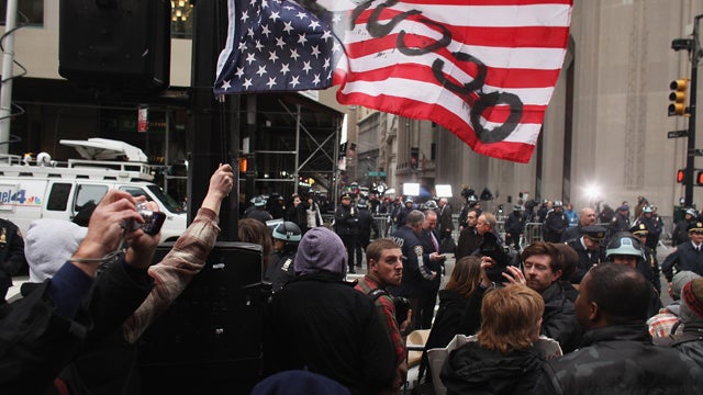 Protesters stand across from Wall Street  