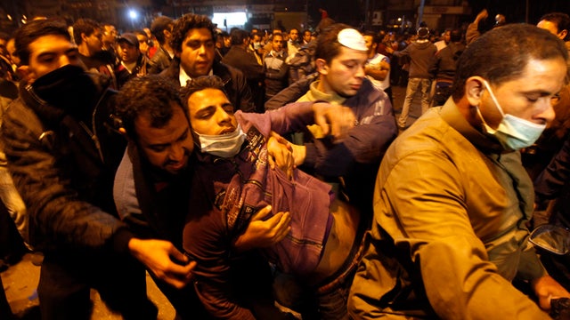 Protesters carry a man wounded during clashes with Egyptian riot police in Tahrir Square in Cairo Nov. 21, 2011. Egypt's army-appointed government handed in its resignation, trying to stem a spiraling crisis as thousands of protesters clashed for the thir 