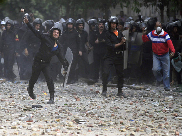 Egyptian riot police throw stones during clashes with protesters  