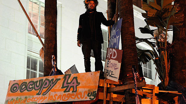 An Occupy LA protester perched in tree house in between plam trees occupies the front lawn of Los Angeles City Hall after the midnight deadline expiration set by Los Angeles city officials to shut down the encampment on November 27, 2011 in Los Angeles, C 
