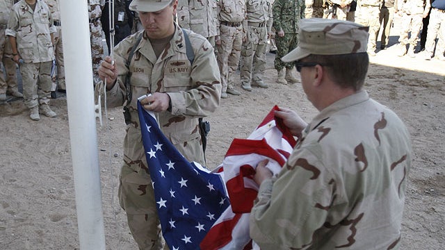 U.S. servicemen fold the American flag after it was lowered during the a handover ceremony of a military base in Basra, Iraq's second-largest city, 340 miles southeast of Baghdad, Iraq, Dec. 1, 2011.  