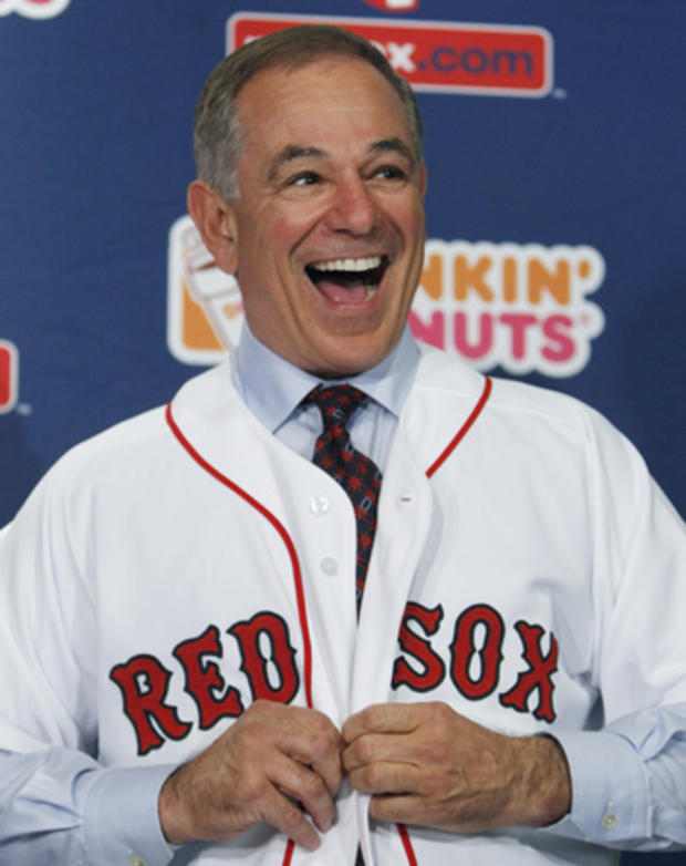 Bobby Valentine laughs as he puts on a jersey 