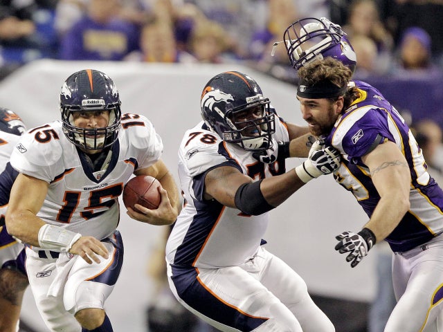 Jared Allen loses his helmet as Tim Tebow (15) runs 