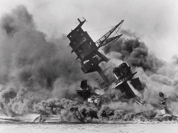 USS Arizona belches smoke as it topples into Pearl Harbor 