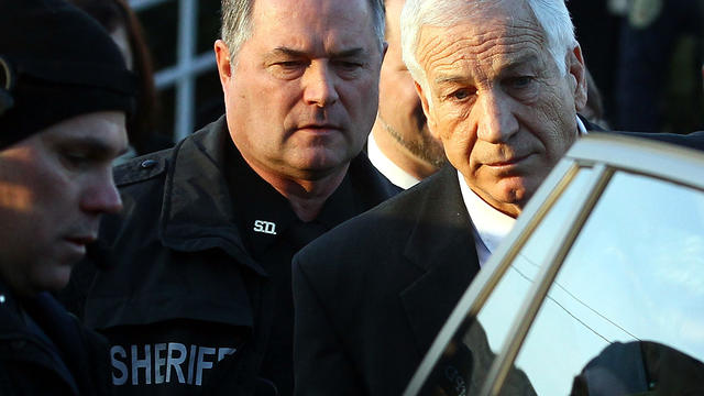 Former Penn State assistant football coach Jerry Sandusky is escorted to his car while leaving the Centre County Courthouse Dec. 13, 2011, in Bellefonte, Pa. Sandusky has been charged with sexual abuse involving 10 boys he met through the nonprofit organi 