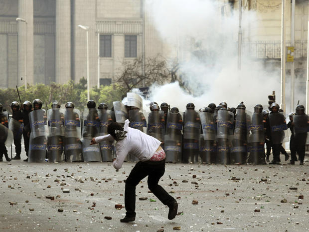 Egyptian protester throws stones riot police 