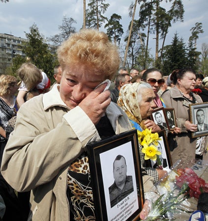 widows of Chernobyl victims hold portraits of their husbands 