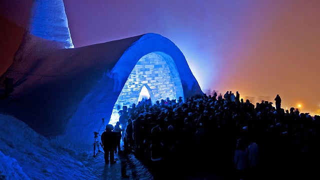 Visitors stand in front of a blue-lit church built of snow during its opening in Mitterfirmiansreut, southern Germany, Dec. 28, 2011.  