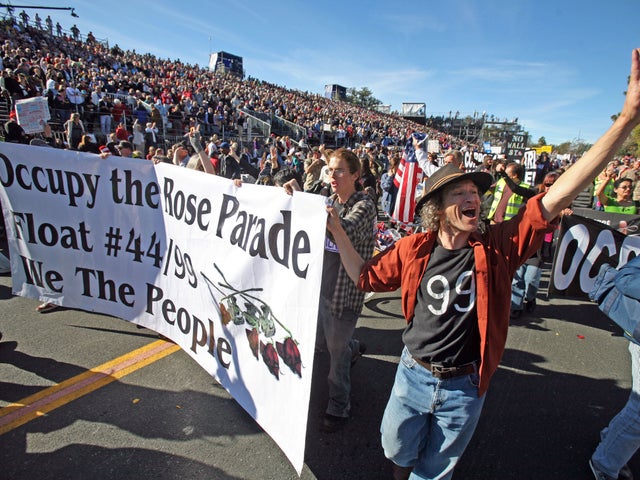 Occupy protesters march along Colorado Boulevard during the 123rd Tournament of Roses Parade in Pasadena, Calif., Monday, Jan. 2, 2012. Several thousand Occupy protesters marched at the end of the Rose Parade in a pre-arranged demonstration.  