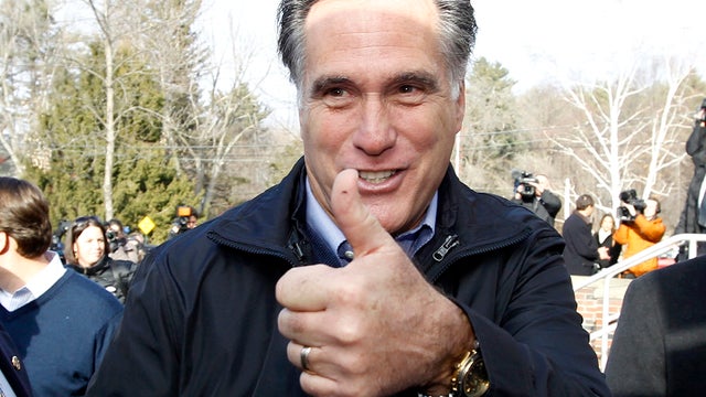 Former Massachusetts Gov. Mitt Romney gives a thumbs up as he campaigns on primary day outside a polling station at Webster School in Manchester, N.H., Jan. 10, 2012. 
