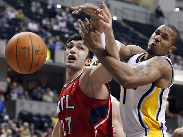 David West and Zaza Pachulia get tied up as they go for a rebound  