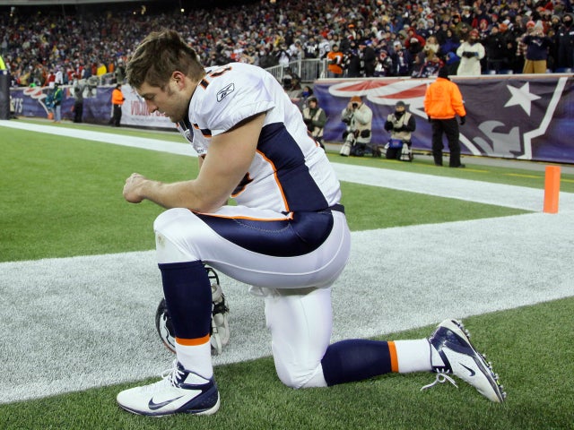 Tim Tebow kneels on the sidelines 
