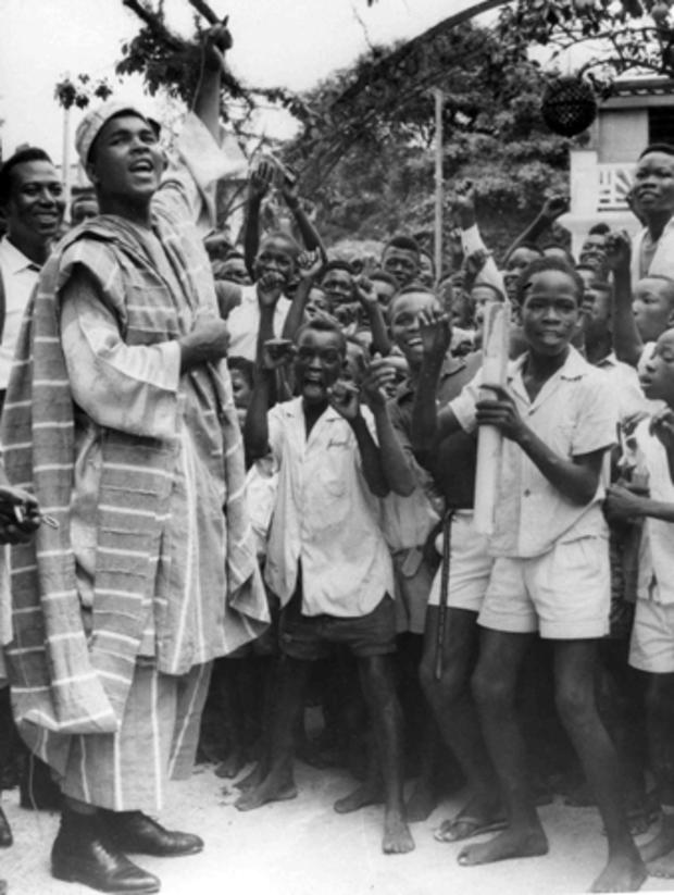Muhammad Ali wearing the Nigerian brown and white striped Agbada costume 