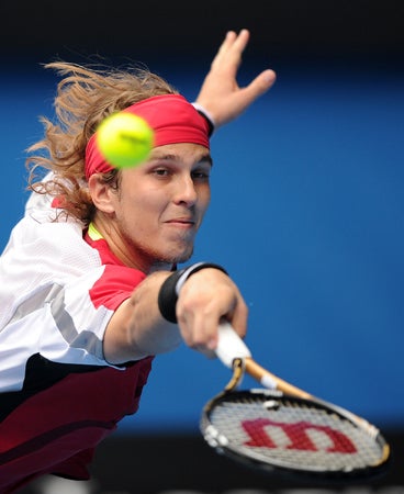 Lukas Lacko makes a backhand return to Rafael Nadal  