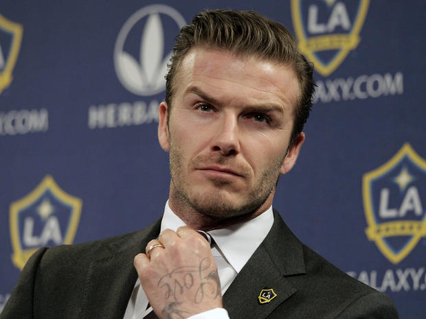 David Beckham fixes his tie during a soccer news conference  
