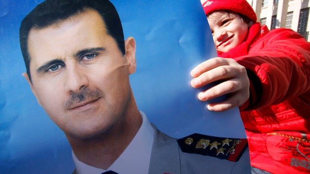 Pro-Syrian regime protester holds a portrait of Syrian President Bashar Assad 