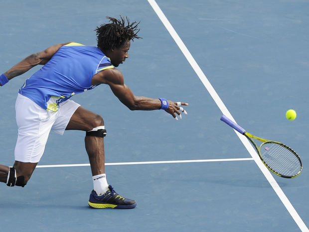 Gael Monfils throws his racket at the ball  