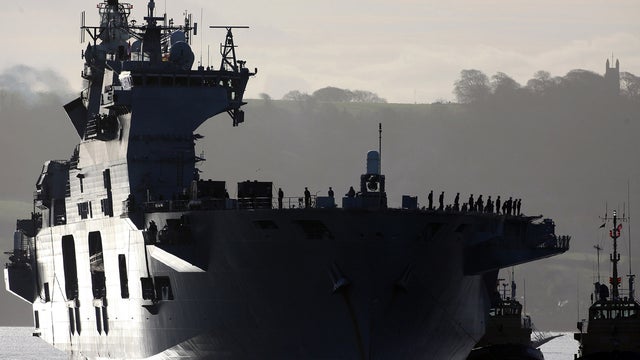 Some of the crew of the HMS Ocean stand on deck as it returns to dock Dec. 9, 2011, in Plymouth, England. 