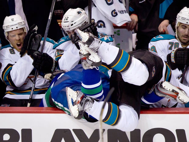 Jamie McGinn checks Dan Hamhuis into the San Jose bench  