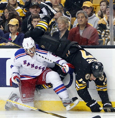 Milan Lucic falls over Dan Girardi 