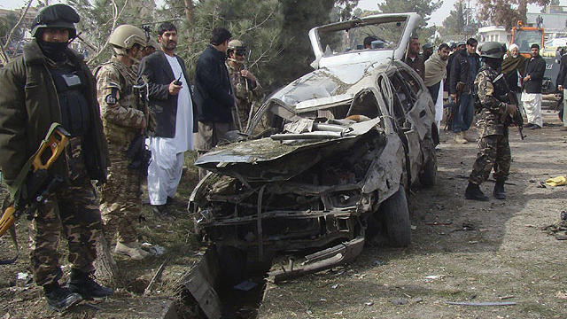 A damaged car is seen at the scene of a suicide attack in Lashkar Gah, Helmand province south of Kabul, Afghanistan, Jan. 26, 2012.  