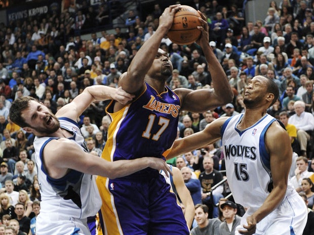 Andrew Bynum attempts to shoot as Kevin Love and Anthony Randolph defend 