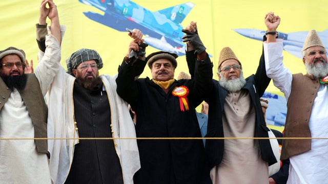 Pakistani Islamist and political party leaders, from left to right Hafiz Muhammad Saeed, Maulana Sami ul Haq, Hamid Gul, Syed Munawar Hasan and Muhammad Ahmed Ludhianvi, raise hands in solidarity at a Pakistan Defense Council rally in Rawalpindi, Pakistan 