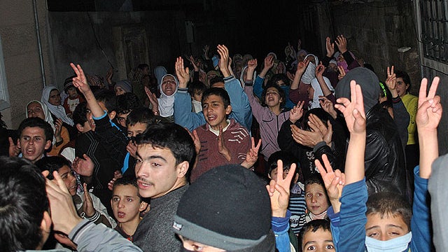 Anti-Syrian regime protesters chant slogans against Syrian President Bashar Assad during an evening protest, in an alley in the Rastan area in Homs province, central Syria, on Jan. 30, 2012. 