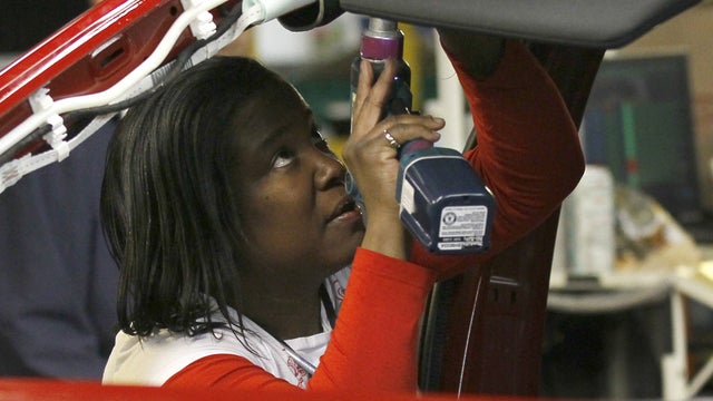 An auto worker assembles parts on the 2013 Dodge Dart  