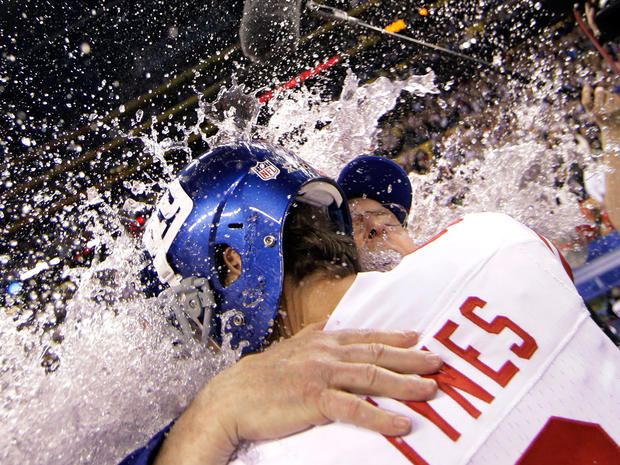 Lawrence Tynes hugs head coach Tom Coughlin as they get doused 