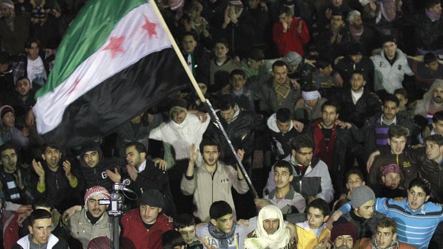 In this Sunday, Feb. 5, 2012 photo, Syrian protesters wave a revolutionary flag during a demonstration in Idlib, Syria.  