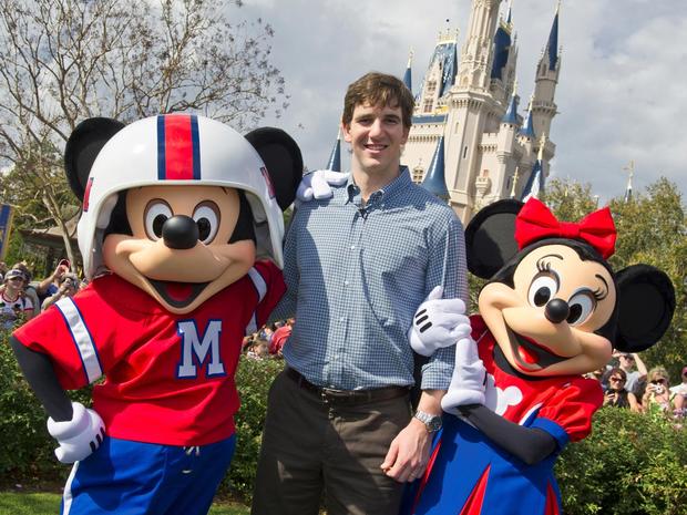 New York Giants quarterback Eli Manning poses with Mickey and Minnie Mouse  