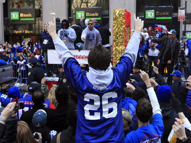 Giants fans wave and take photos as the floats carrying players 