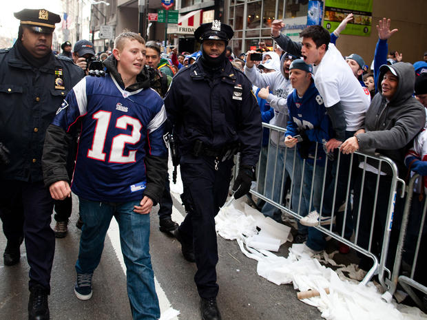 New York Giants fans jeer a New England Patriots fan after he is led away 